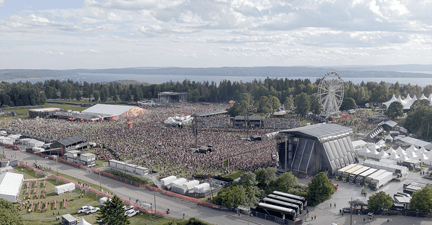 oversikt over festivalområde, tett med mennesker, fjord i bakgrunnnen