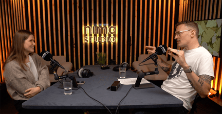 En kvinne og en mann snakker sammen i et podkaststudio. 