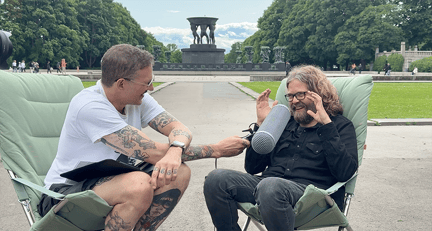 to menn sitter på campingstoler i Frognerparken og snakker i en mikrofon