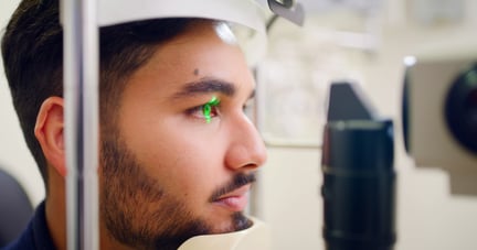 mann med laser i øyet hos optiker