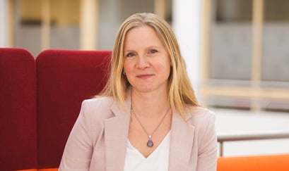 Portrett av Mari Sundli Tveit i en rød sofa