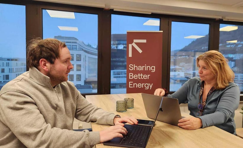 en kvinne og en mann diskuterer rundt et bord