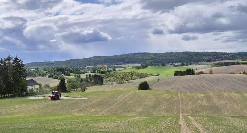 traktor sprer gjødsel på åker 