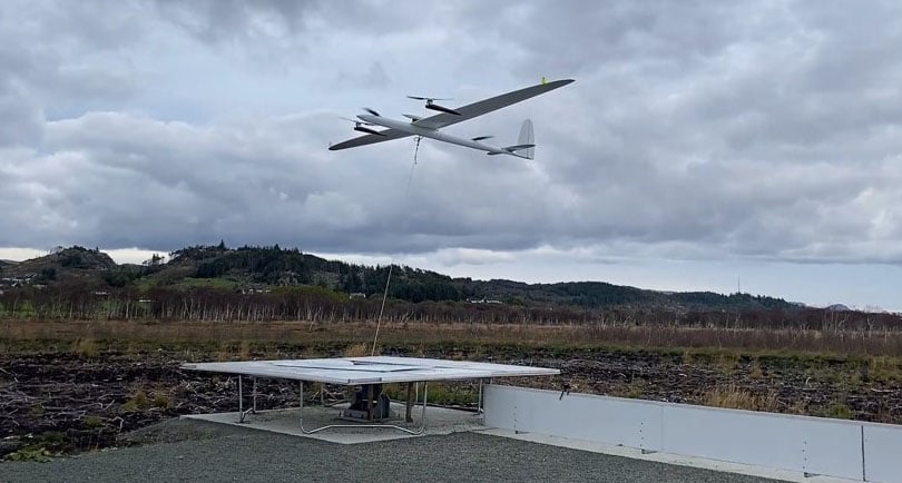 kitemills fastvingete drage flyr i lufta, grå himmel