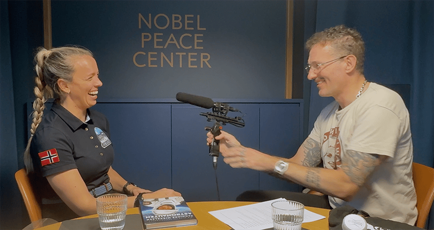 kvinne og mann i et studio med en mikrofon mellom seg, det står Nobel Peace Center på veggen bak dem.