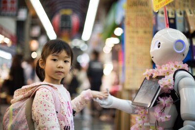 Asiatisk jente håndhilser med robot