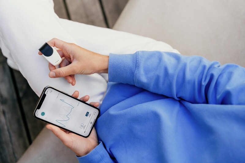 Person som måler helsedata, med mobil