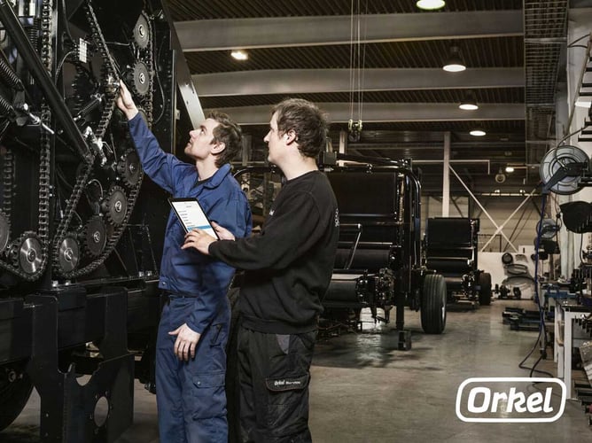 Bilde som viser arbeidere ved Orkel AS som arbeider med en maskin