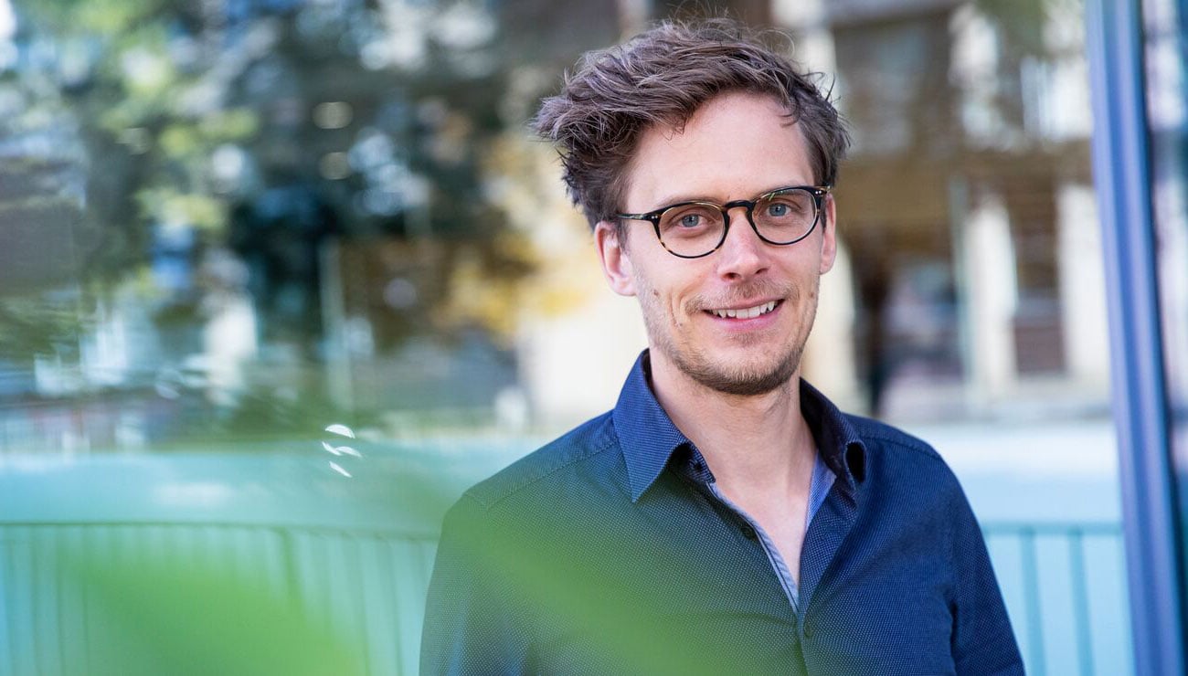 Portrett a smilende ung mann med briller